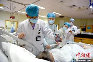 clip_image004.jpg 说明: 重症监护室一患者通过“云探视”服务与家人视频通话 陈真真 摄